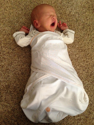 yawning baby in swaddle